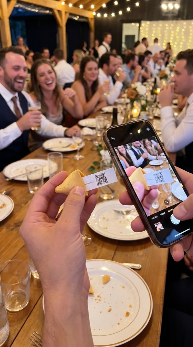 Invitados fotografiando el código QR de una galleta de la suerte en el banquete de boda
