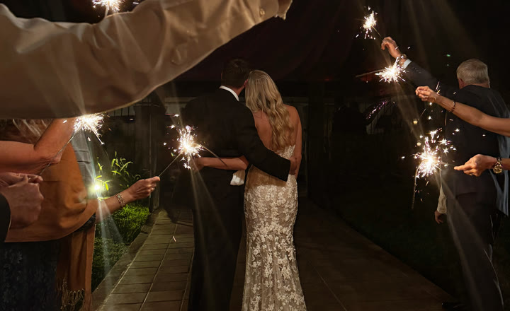 Novios saliendo de su boda entre bengalas encendidas por los invitados