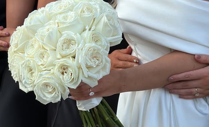 Novia sujetando su ramo de rosas blancas el día de la boda